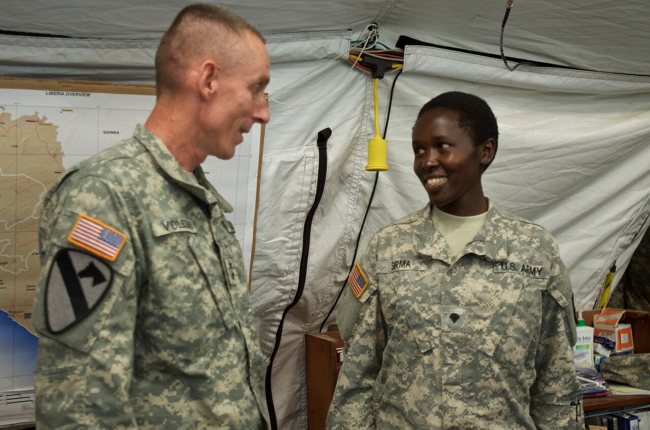 Army Maj. Gen. Gary Volesky recognizes Army Spc. Rysper Sirma for her exemplary performance while supporting Operation United Assistance at the Barclay Training Center, Monrovia, Liberia, Dec. 26, 2014. As a food inspection specialist, Sirma ensures the food and water her fellow service members consume are safe. U.S. Army photo by Staff Sgt. V. Michelle Woods