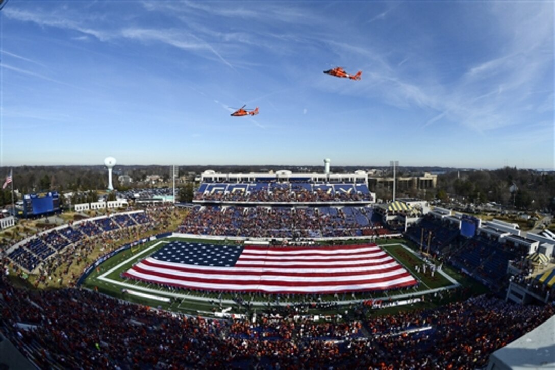 Coast Guard H-65 helicopters fly over Navy-Marine Corps Memorial Stadium at the start of the Military Bowl 2014 in Annapolis, Md., Dec. 27, 2014.