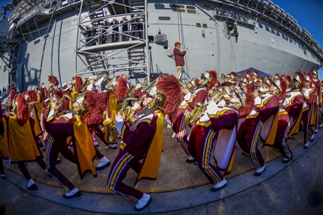 The University of Southern California marching band performs during a Battle of the Bands competition beside the USS Essex in San Diego, Dec. 26, 2014. The Essex hosted the 37th annual 2014 Navy and Marine Corps Holiday Bowl luncheon aboard the ship.