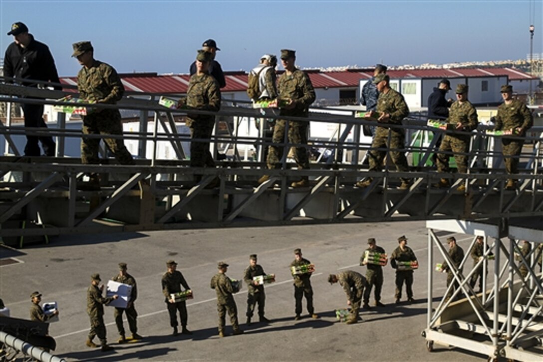 U.S. Marines load supplies onto the USS Iwo Jima on Naval Station Rota, Spain, Dec. 26, 2014. The Marines are assigned to the 24th Marine Expeditionary Unit.