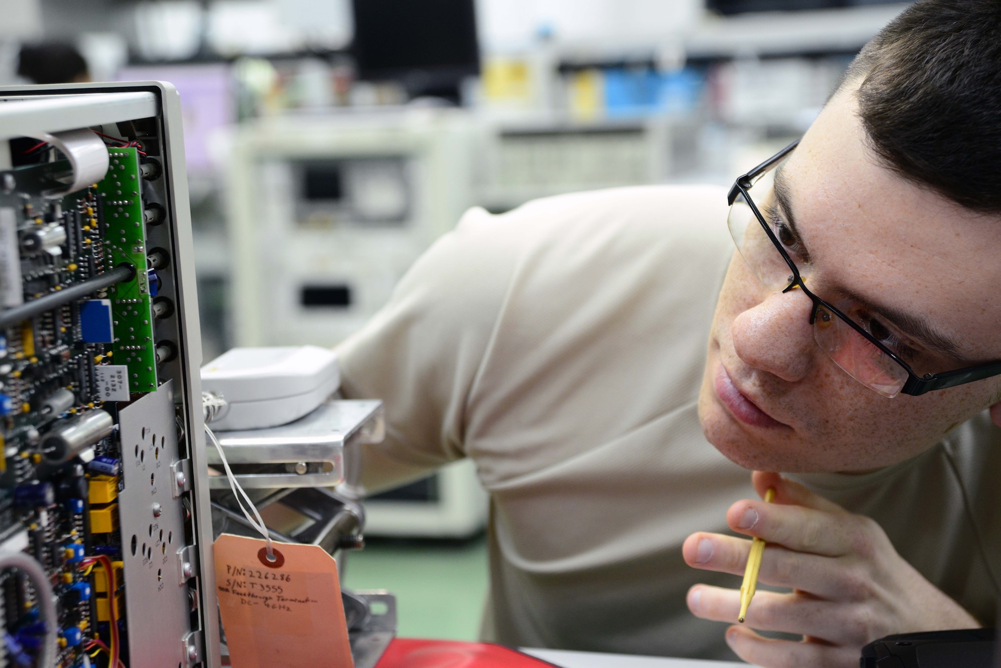 Staff Sgt. Corey Crim inspects an oscillator in the Precision Measurement Equipment Laboratory March 28, 2014, at Misawa Air Base, Japan. As part of the PMEL flight, Crim and his coworkers calibrate more than 4,000 units annually for multiple agencies across base. Crim is from the 35th Maintenance Squadron. (U.S. Air Force photo/Senior Airman Derek VanHorn) 