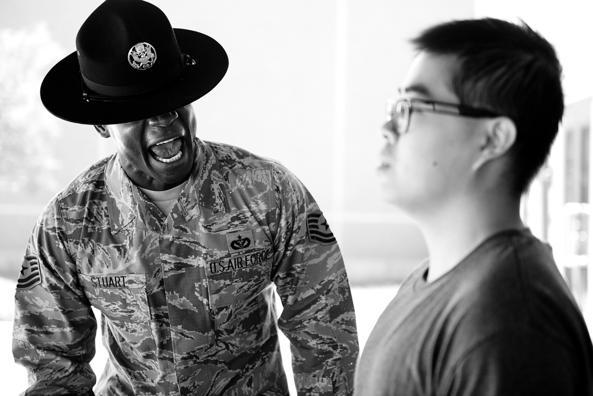 Tech. Sgt. Chananyah Stuart reminds a trainee of the procedures for entering the dining facility Sept. 26, 2014, at Joint Base San Antonio-Lackland, Texas. Stuart is extra demanding on his trainees from the very beginning because he believes it sets them up for success. Stuart is a 323rd training Squadron military training instructor. (U.S. Air Force photo/Master Sgt. Jeffrey Allen)