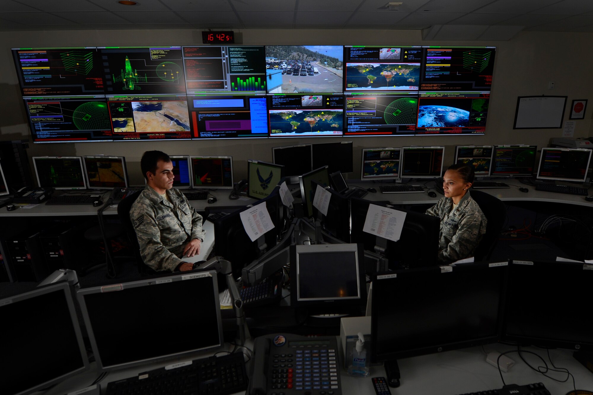 Staff Sgt. Alex Garviria, 721st Communication Squadron senior systems controller, and 2nd Lt. Rachel James, 721st CS crew commander, work in the Global Strategic Warning and Space Surveillance System Center at Cheyenne Mountain Air Force Station, Colo., Sept. 2, 2014. The 721st CS provides continuous monitoring of the strategic missile warning systems to ensure a constant dataflow of key information to North American Aerospace Defense Command (NORAD), U.S. Northern Command, U.S. Strategic Command, Air Force Space Command, Secretary of Defense, President of the United States, strategic, and theater commanders. (U.S. Air Force photo by Airman 1st Class Krystal Ardrey)