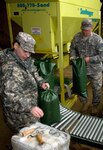Army Pfc. Matthew J. Ohman and Pvt. Carey A. Clarke, both of the 272nd Chemical Company of the Massachusetts Army National Guard, work together filling sandbags at the Massachusetts Department of Transportation-Highway Division in Lexington, Mass., March 29, 2010.