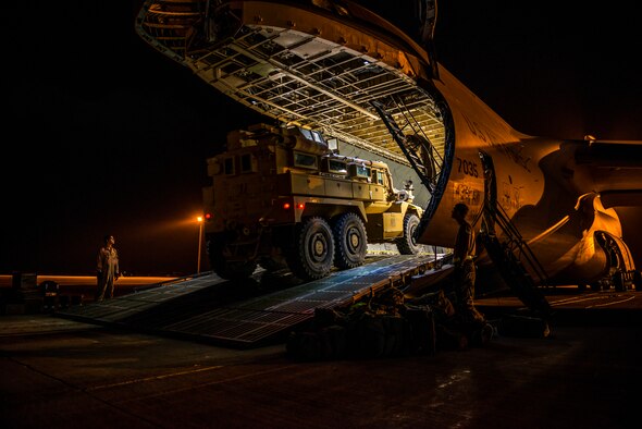 Airmen with the 9th Airlift Squadron and 455th Expeditionary Aerial Port Squadron with Marines from the Marine Expeditionary Brigade prepare to load vehicles into a C-5M Super Galaxy Oct. 6, 2014, at Camp Bastion, Afghanistan. Airmen and Marines loaded more than 266,000 pounds of cargo onto the C-5M as part of retrograde operations in Afghanistan. (U.S. Air Force photo/Staff Sgt. Jeremy Bowcock)