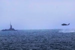 JAVA SEA, AT SEA (Dec. 31, 2014) - An MH-60R Seahawk helicopter attached to USS Sampson approaches an Indonesian patrol vessel while searching for debris to support the Indonesian-led recovery operation for the downed AirAsia Flight 8501.  (U.S. Navy photo)  