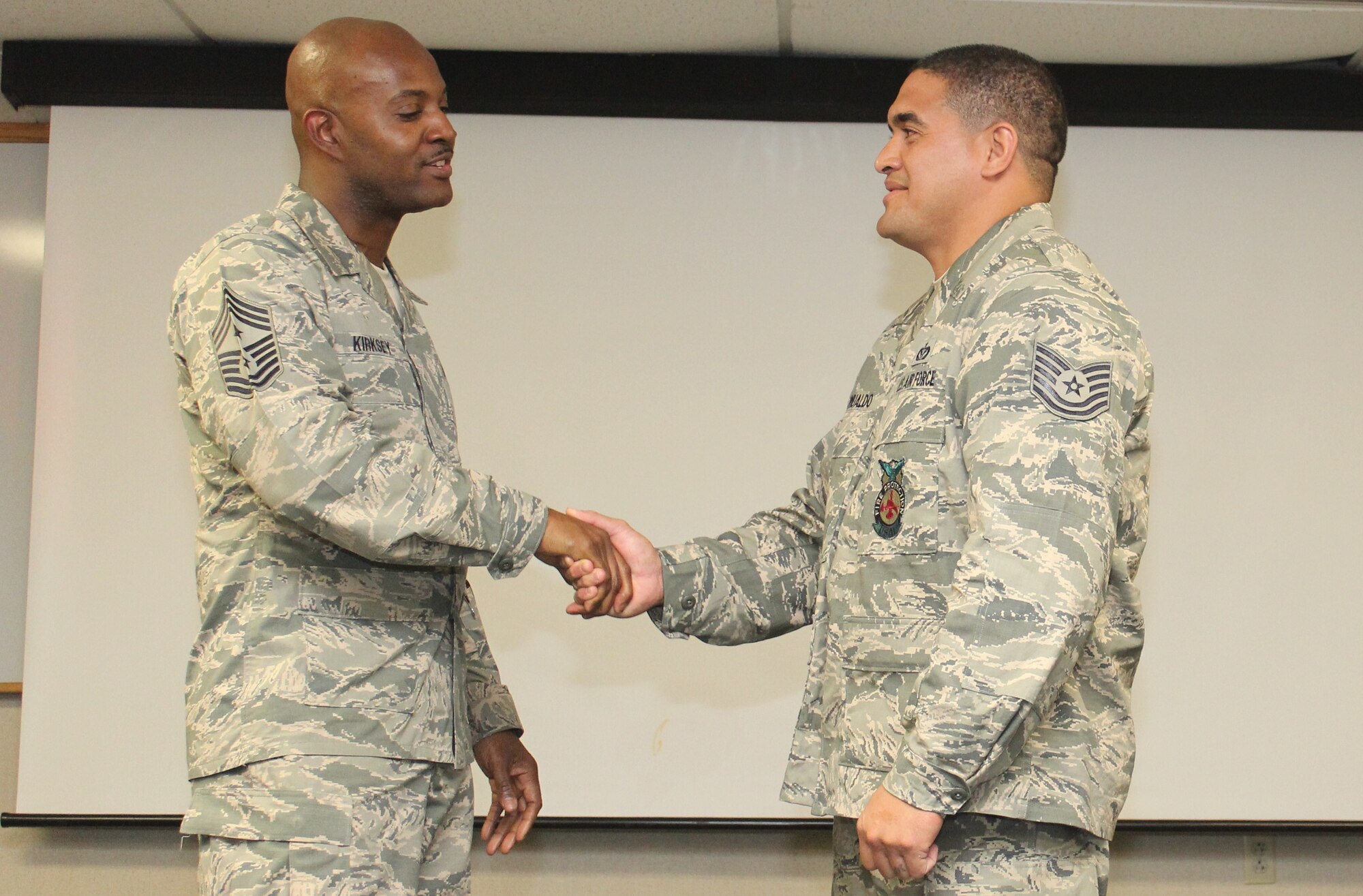 Chief Master Sgt. Cameron Kirksey, right, command chief of Air Force Reserve Command, Robins Air Force Base, Georgia, thanks Tech. Sgt. Kaohilii Romualdo , left, a firefighter with the 624th Civil Engineering Squadron, for his commitment to service before self after presenting him with a command chief's coin as a reward for excellent performance as an Air Force Reserve member, Joint Base Pearl Harbor-Hickam, Hawaii, Dec. 6, 2014. (U.S. Air Force photo by Master Sgt. Cris Ildefonso)