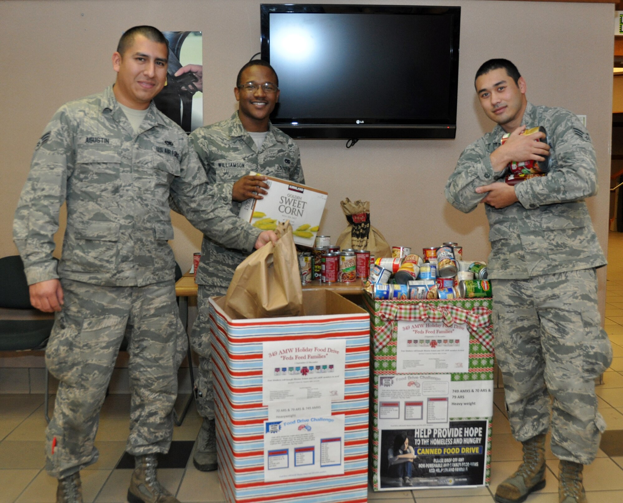 TRAVIS AIR FORCE BASE, Calif. -- Senior Airman Saul Agustin, a jet engine technician, Airman 1st Class Denzel Williamson and Senior Airman Jason Abbitt, both aerospace maintenance technicians, part of the 749th Aircraft Maintenance Squadron showcase the unit’s generosity November 23, 2014.  (U.S. Air Force photos/ Staff Sgt. Cindy G. Alejandrez)