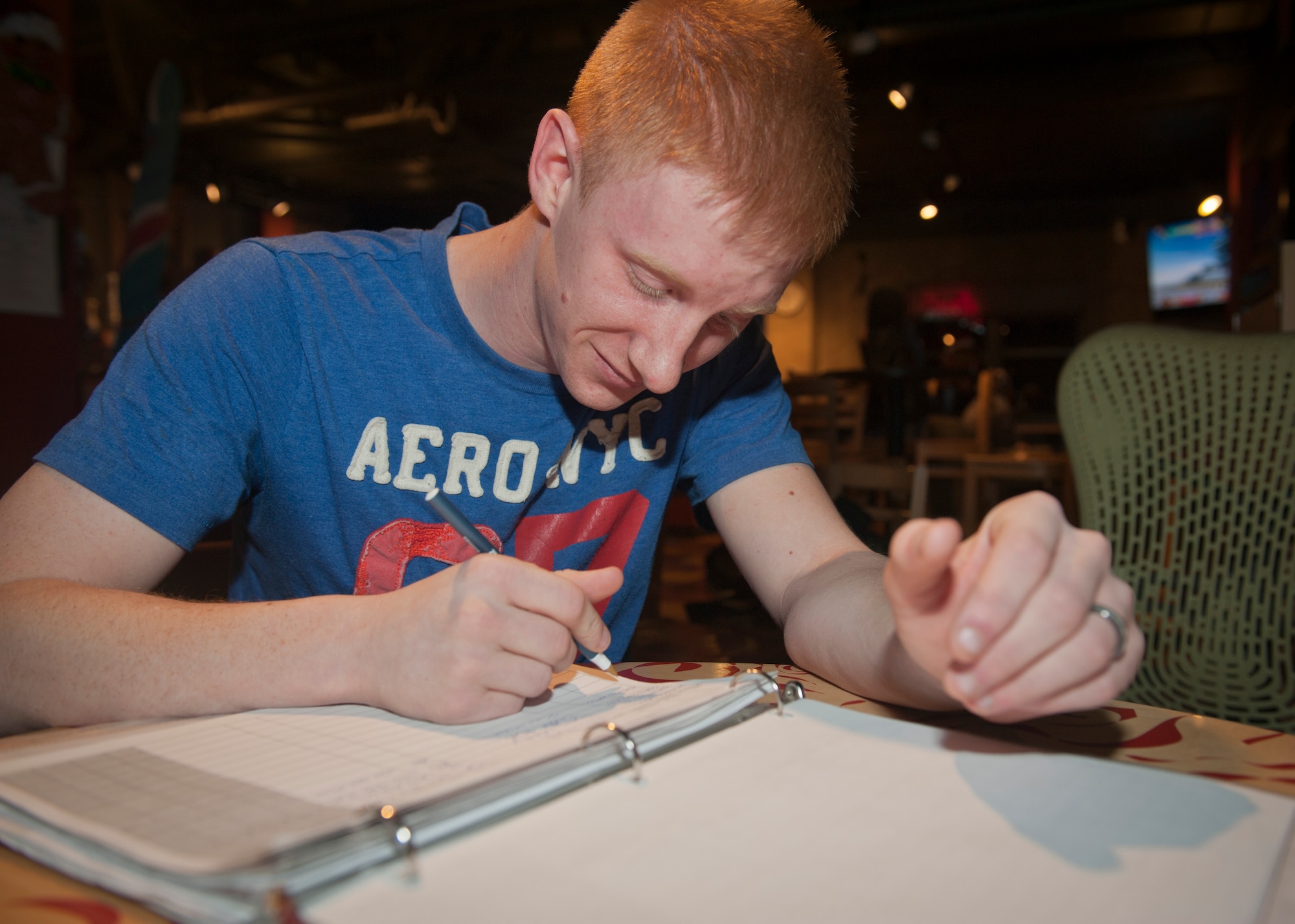 PETERSON AIR FORCE BASE, Colo. – Airman 1st Class Steve Evans, Airmen Against Drunk Driving treasurer, signs in at the beginning of the night to keep records updated before volunteering for the night at the Eclipse Café, Dec. 27, 2014. Volunteers need to provide their name and phone number as well as insurance information and a valid driver’s license before being a driver. By keeping records, the A2D2 board can reward regular volunteers through their incentive program and hopefully encourage more Airmen to volunteer their time. (U.S Air Force photo by Airman 1st Class Rose Gudex)