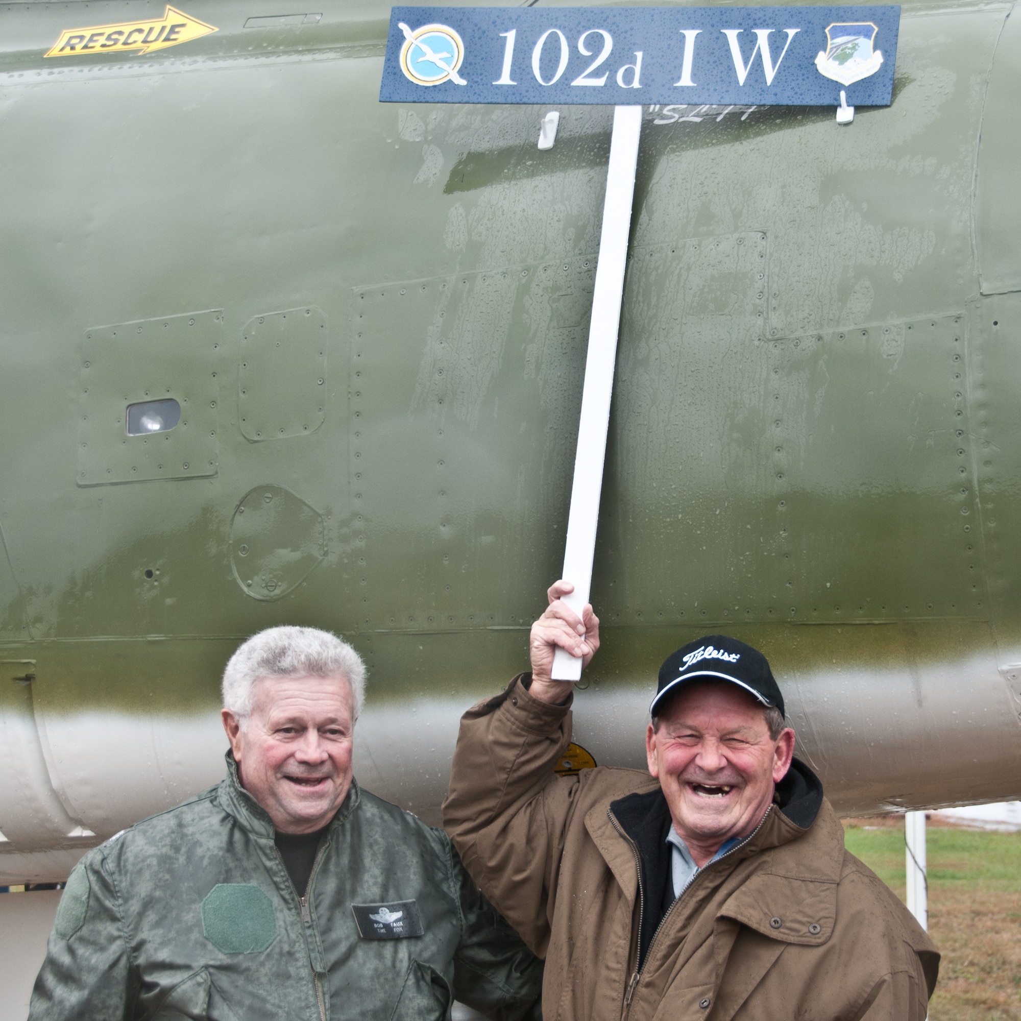 Retired Senior Master Sgt. Thomas Connors, a former F-100 crew-chief, pulls a cover off of a F-100 static display aircraft during a dedication ceremony on Otis Air National Guard Base, November 1, 2014. Connors' name was stenciled onto the aircraft as the crew-chief  because of his many contributions to the 102nd.(Air National Guard photo by Staff Sergeant Patrick McKenna/Released)