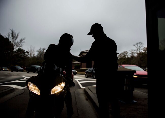 Officer Patrick Traywick, from the 628th Security Forces Squadron, checks a motorcyclist’s credentials at the Dorchester gate, Dec. 30, 2014, at Joint Base Charleston S.C. The 628th SFS defends all assets and personnel on JB Charleston, even during the holiday season when many Airmen and Sailors are taking time off. During the holidays, SFS forces switch to 12-hour shifts instead of their usual eight, and divide their duties into two elements to allow their personnel time off for the holidays. One element works the week of Christmas and the other element works the week of New Years.  (U.S. Air Force photo/Senior Airman Jared Trimarchi) 