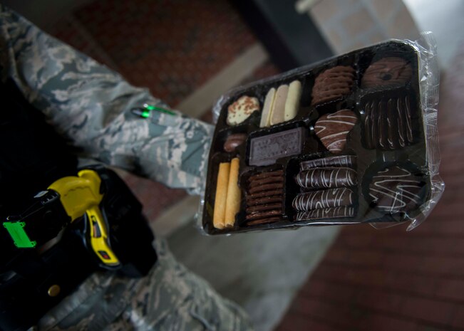 Airman 1st Class Hunter Banks, 628th Security Forces installation entry controller, holds a package of cookies given to him by a base visitor as thanks for working during the holidays Dec. 30, 2014, at Joint Base Charleston S.C. The 628th SFS defends all assets and personnel on JB Charleston, even during the holiday season when many Airmen and Sailors are taking time off. During the holidays, SFS forces switch to 12-hour shifts instead of their usual eight, and divide their duties into two elements to allow their personnel time off for the holidays. One element works the week of Christmas and the other element works the week of New Years. (U.S. Air Force photo/Senior Airman Jared Trimarchi) 
 
