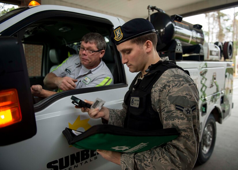 Airman 1st Class Hunter Banks, 628th Security Forces installation entry controller, checks a contractor’s credentials before he can enter the installation, Dec. 30, 2014, at Joint Base Charleston S.C. The 628th SFS defends all assets and personnel on JB Charleston, even during the holiday season when many Airmen and Sailors are taking time off. During the holidays, SFS forces switch to 12-hour shifts instead of their usual eight, and divide their duties into two elements to allow their personnel time off for the holidays. One element works the week of Christmas and the other element works the week of New Years.  (U.S. Air Force photo/Senior Airman Jared Trimarchi) 
 
