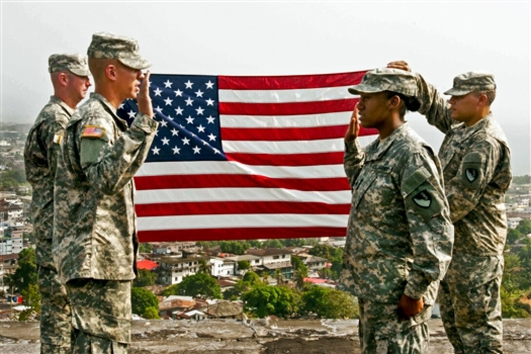 U.S. Army 2nd Lt. Charles Stewart, left, re-enlists U.S. Army Sgt. Brittney Washington on top of a building overlooking Monrovia, Liberia, Dec. 23, 2014. Stewart is an executive officer and Washington is a food service noncommissioned officer assigned to Forward Support Company, 62nd Engineer Battalion, 36th Engineer Brigade.