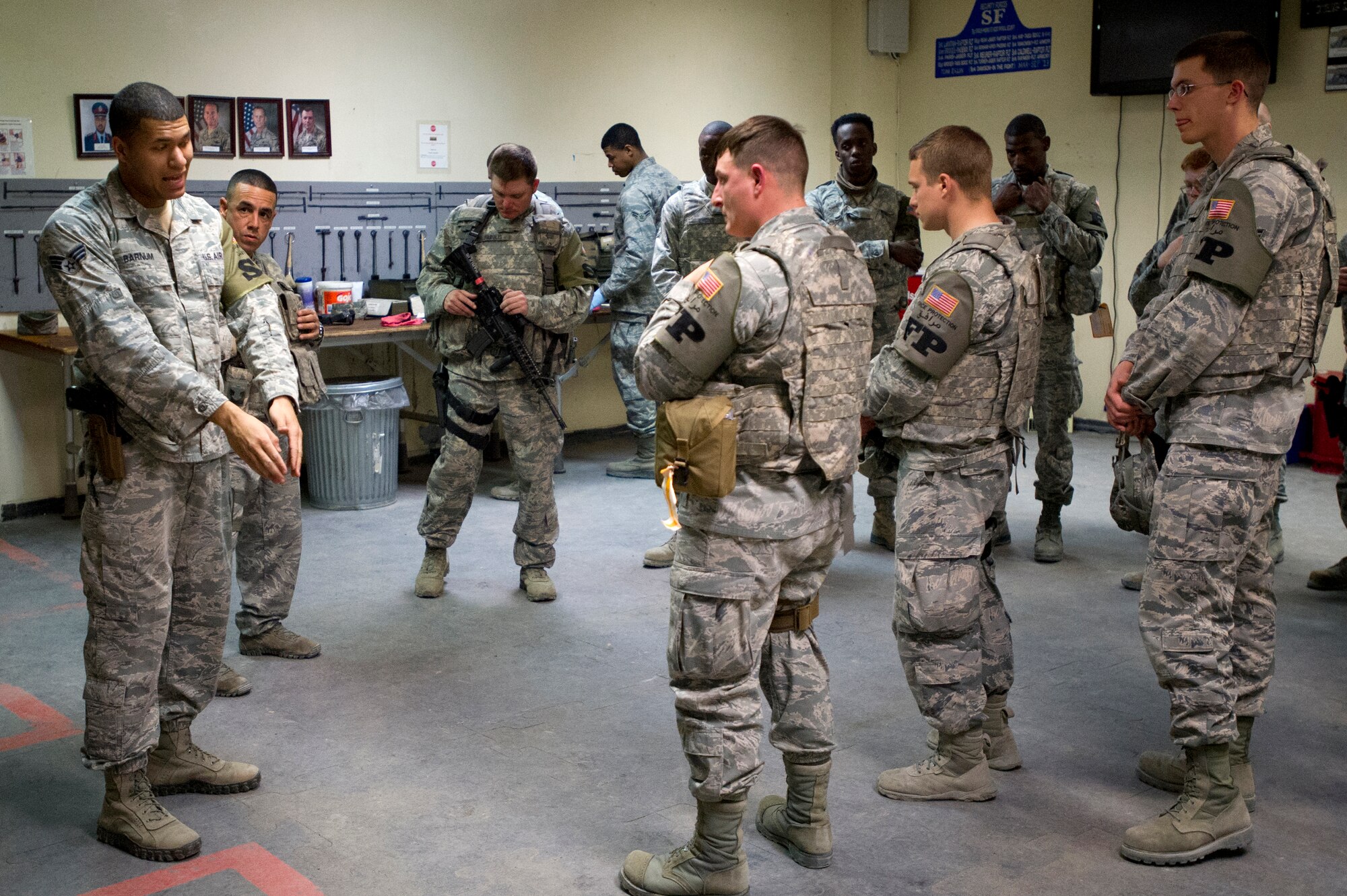 Senior Airman Steven Barnum, 386th Expeditionary Security Forces Squadron, demonstrates the proper procedure for being issued weapons to a group of Force Protection Airmen.  Force Protection has partnered with Security Forces Defenders as part of a program designed to provide enhanced training opportunities on base defense for FP Airmen.  Force Protection Airmen learned proper procedures necessary to augment Security Forces.  (U.S. Air Force photo by Senior Master Sgt. Burke Baker)