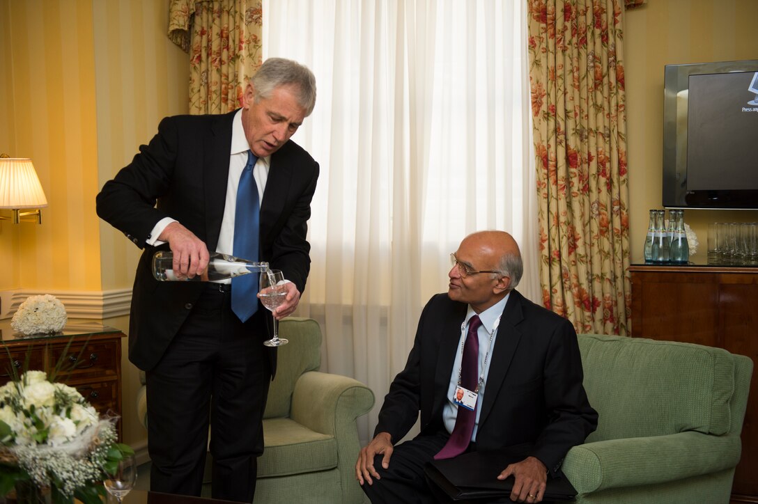 U.S. Defense Secretary Chuck Hagel pours a glass of water for Indian National Security Advisor Shivshankar Menon during their meeting at the Munich Security Conference in Germany, Feb. 1, 2014.