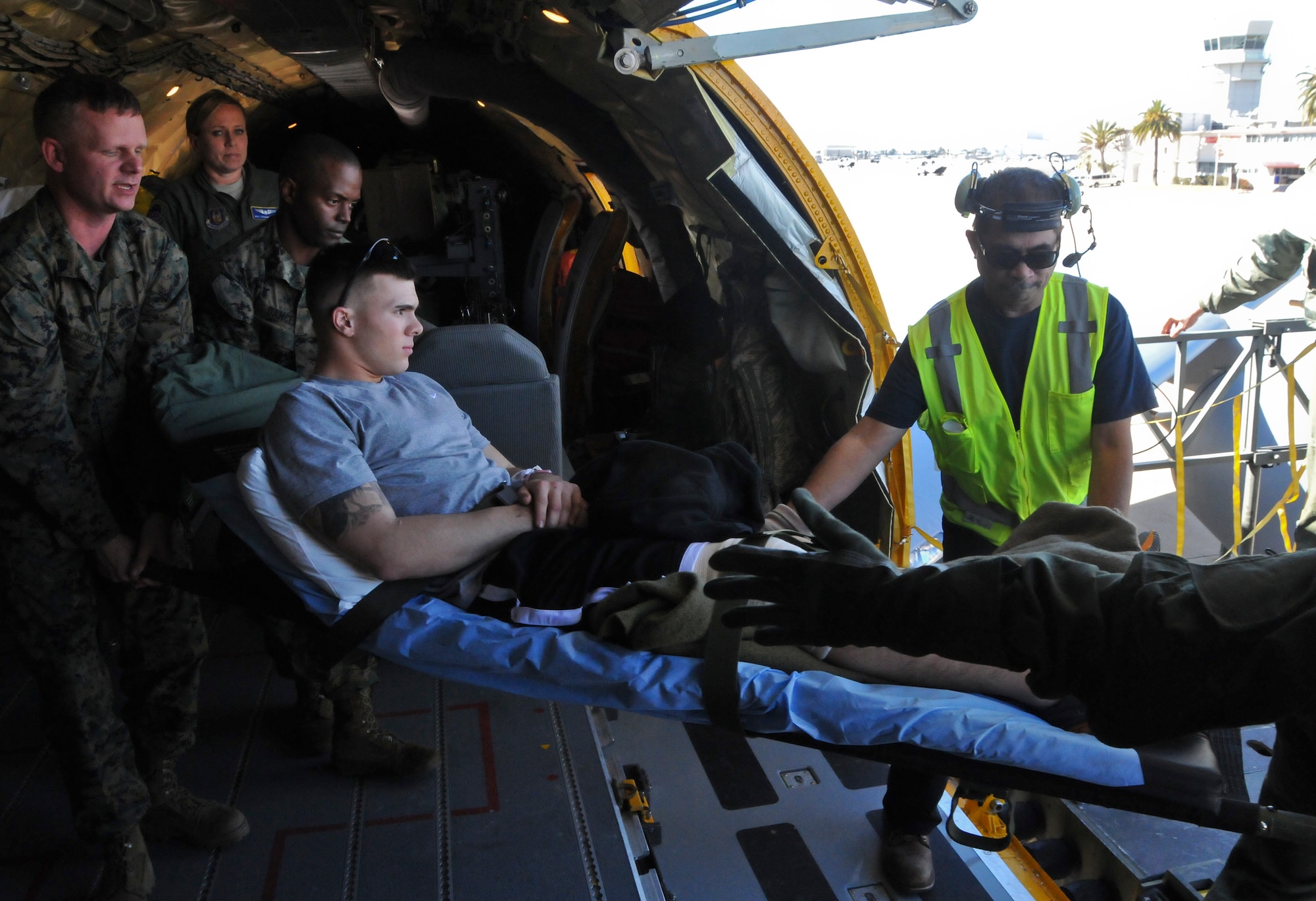 U.S. Marine Lance Cpl. Matt Ehlers assigned to Twenty-nine Palms, Morongo Valley, Ca. is carried by two Marines from Miramar Air Base, San Diego, Ca. as they offload him from the KC-135R Stratotanker assigned to the 128th Air Refueling Wing, Milwaukee, and into a waiting medical transport vehicle Jan 13, 2014. Lance Cpl. Ehlers was injured in Afghanistan and was being flown across the country during a Total Force Integration Aeromedical Evacuation Mission transporting wounded from one medical facility to another. (U.S. Air Guard Photo by Staff Sgt. Jeremy Wilson/Released)