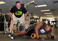 Chris Walter, the 919th Special Operations Wing's new athletic trainer and strength conditioning specialist, helps an Airman with his workout at Duke Field Feb. 1.  Walter's position is part of a new Special Operations Command initiative dedicated to increasing the physical capacity of members from the special operations forces and their families.  (U.S. Air Force photo/Tech. Sgt. Jasmin Taylor)