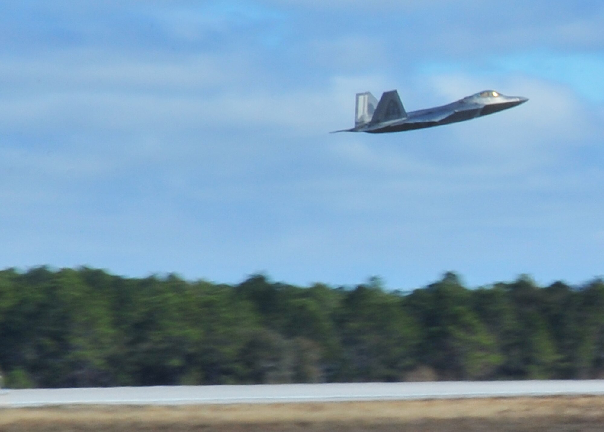 A 43rd Fighter Squadron F-22 Raptor takes off to Savannah, Ga., Feb. 1 from the Tyndall flight line.  The 43rd FS will train at the Georgia Combat Readiness Training Center in a large-scale scenario against multiple aircraft during the first two weeks of Feb. (U.S. Air Force photo by Airman 1st Class Sergio A. Gamboa)