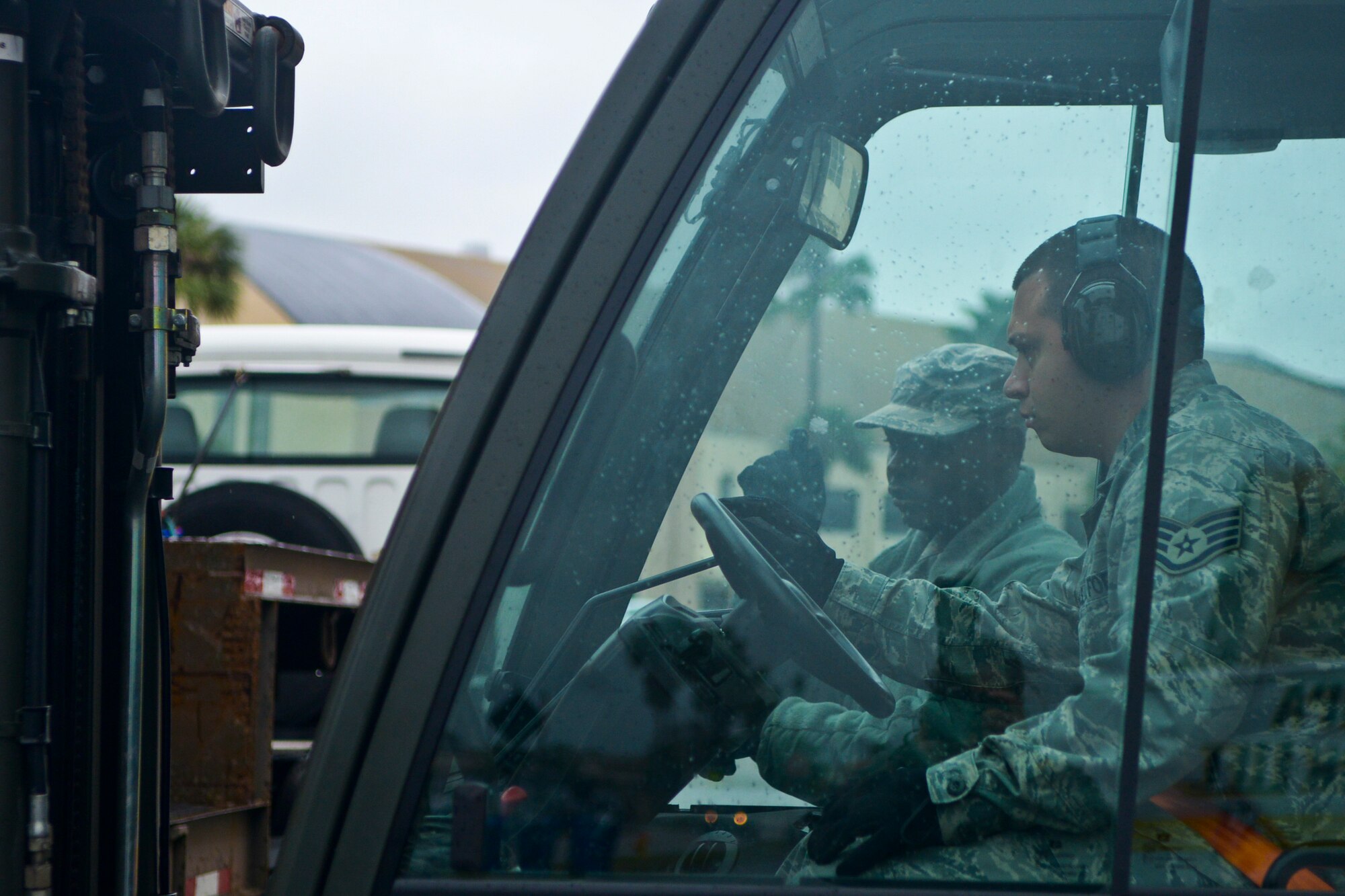 Senior Airman Branden Jones, 6th Logistics Readiness Squadron flight service center, uses hand signals to direct Staff Sgt. Juan Vasquez, 6th LRS NCO in-charge of mobility readiness of spare packages, at MacDill Air Force Base, Fla., Jan. 30, 2014. Jones and Vasquez moved large aircraft parts from a loading dock to a newly renovated storage facility inside hangar two as part of Air Force Smart Operations for the 21st Century. (U.S. Air Force photo by Senior Airman Melissa V. Paradise/Released)