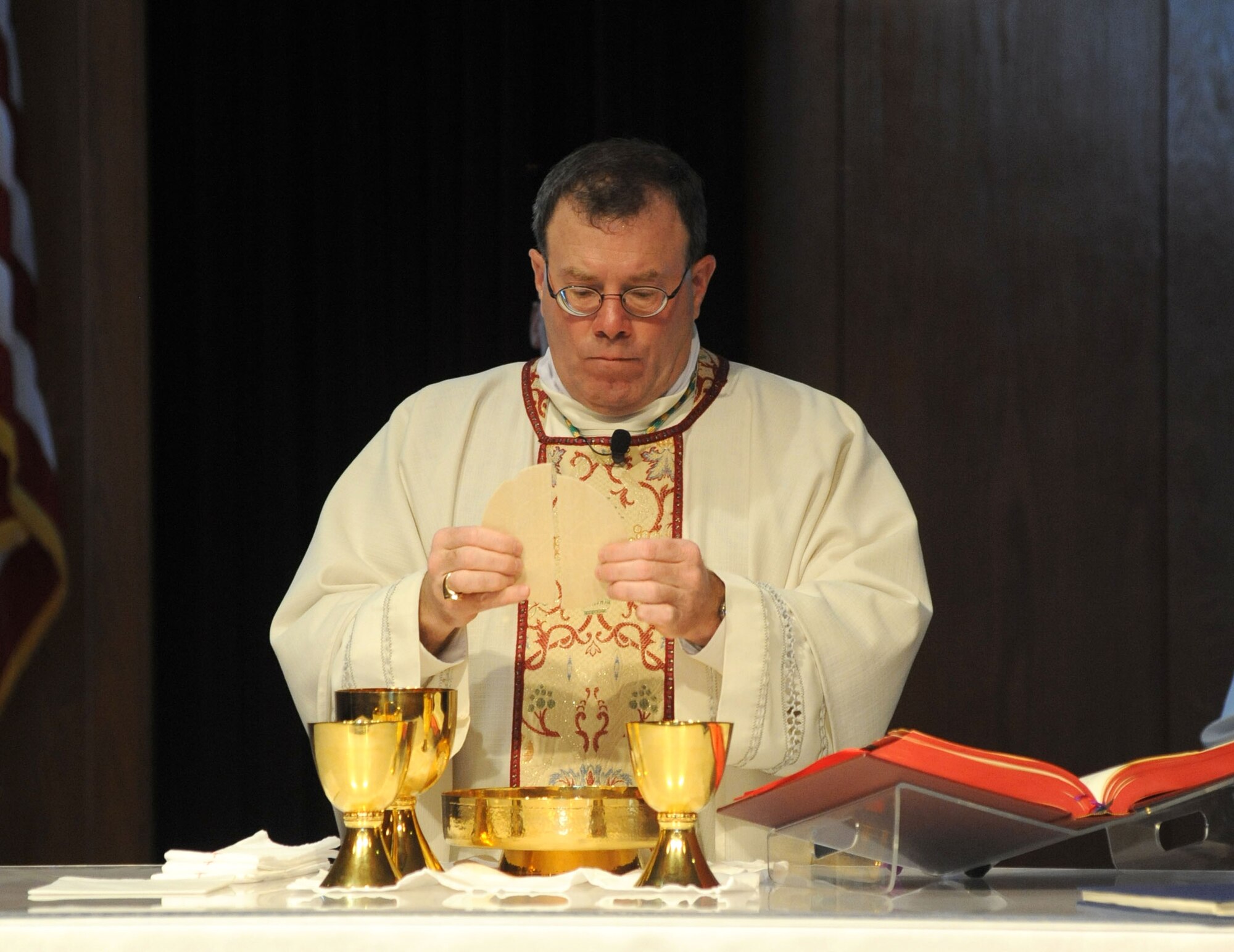 Bishop Neal Buckon, Archdiocese for Military Services, prepares Holy Communion as he leads Keesler’s Catholic Mass, Feb. 2, 2014, at the Triangle Chapel, Keesler Air Force Base, Miss.  Buckon also met with technical training students for prayer and dinner Jan. 31, during his visit to Keesler.  (U.S. Air Force photo by Kemberly Groue)