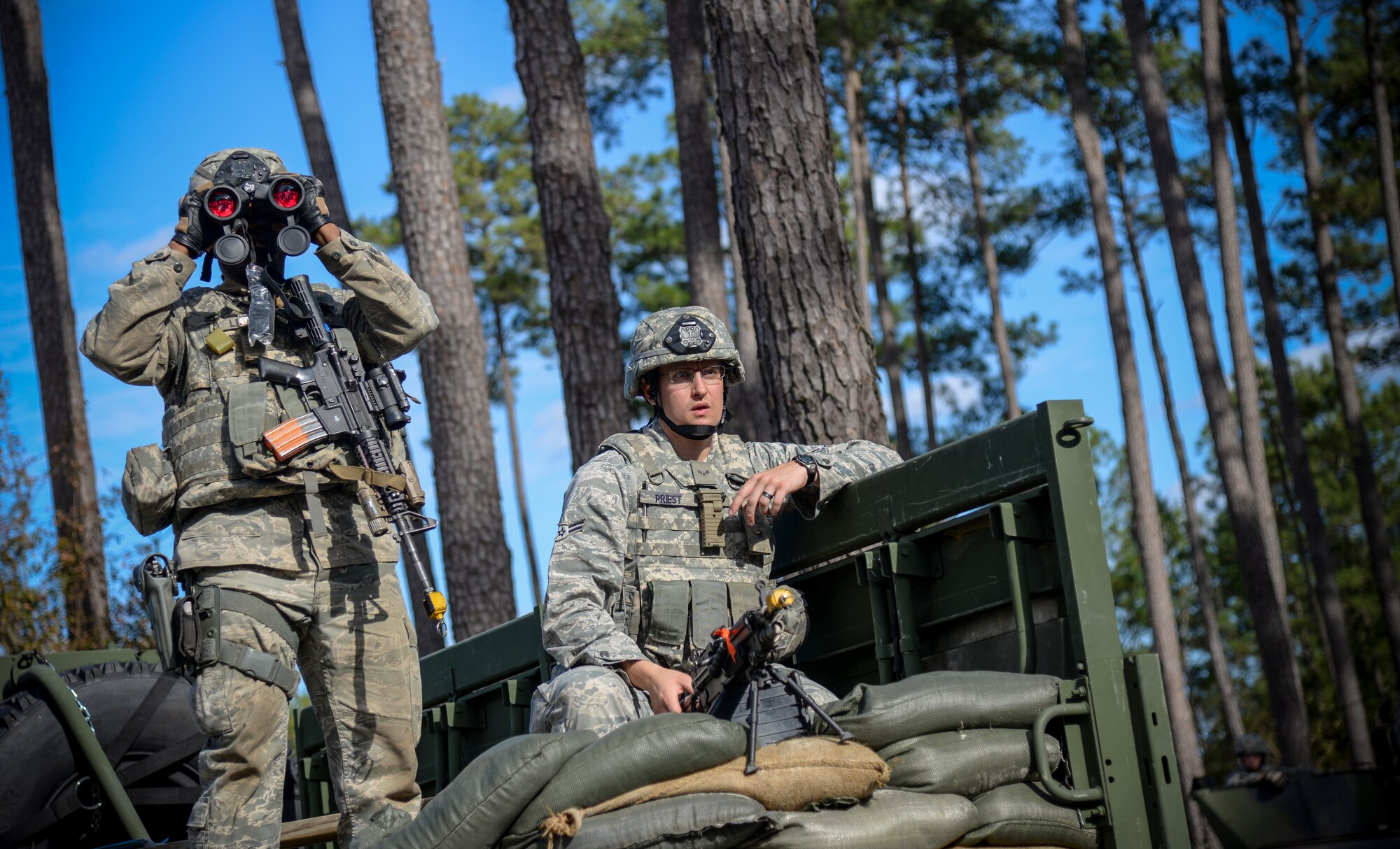 U.S. Air Force Staff Sgt. Courtland Little, 822nd Base Defense Squadron fireteam leader (left) and Airman 1st Class David Priest, 822nd BDS fireteam member, observe a group of protesters during EXERCISE SAFESIDE GUARDIAN, Jan. 27, 2014, at Moody Air Force Base, Ga. The 820th Base Defense Group conducts the tactical and strategic training every three to six months to validate their deployment capabilities. (U.S. Air Force photo by Airman 1st Class Sandra Marrero/Released)