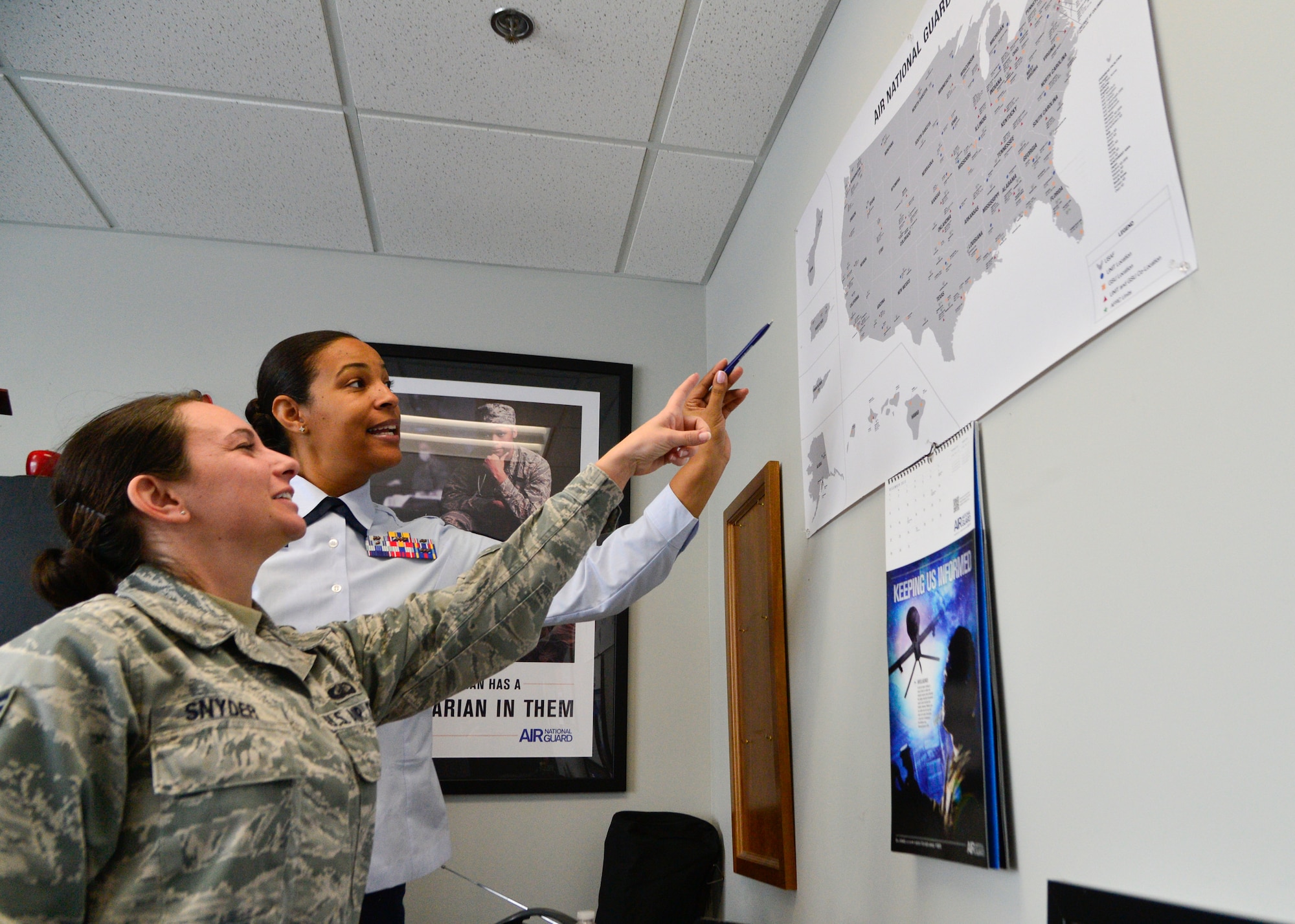 Master Sgt. Valerie Harris, Air National Guard in-service recruiter, shows a map of ANG bases to Senior Airman Patricia Snyder, 436th Comptroller Squadron quality assurance manager, Jan 31, 2014, at Dover Air Force Base, Del. Service men and women in the ANG have the option to pick their bases upon enlistment versus active duty where Airmen are assigned a base. (U.S. Air Force photo/Airman 1st Class William Johnson)