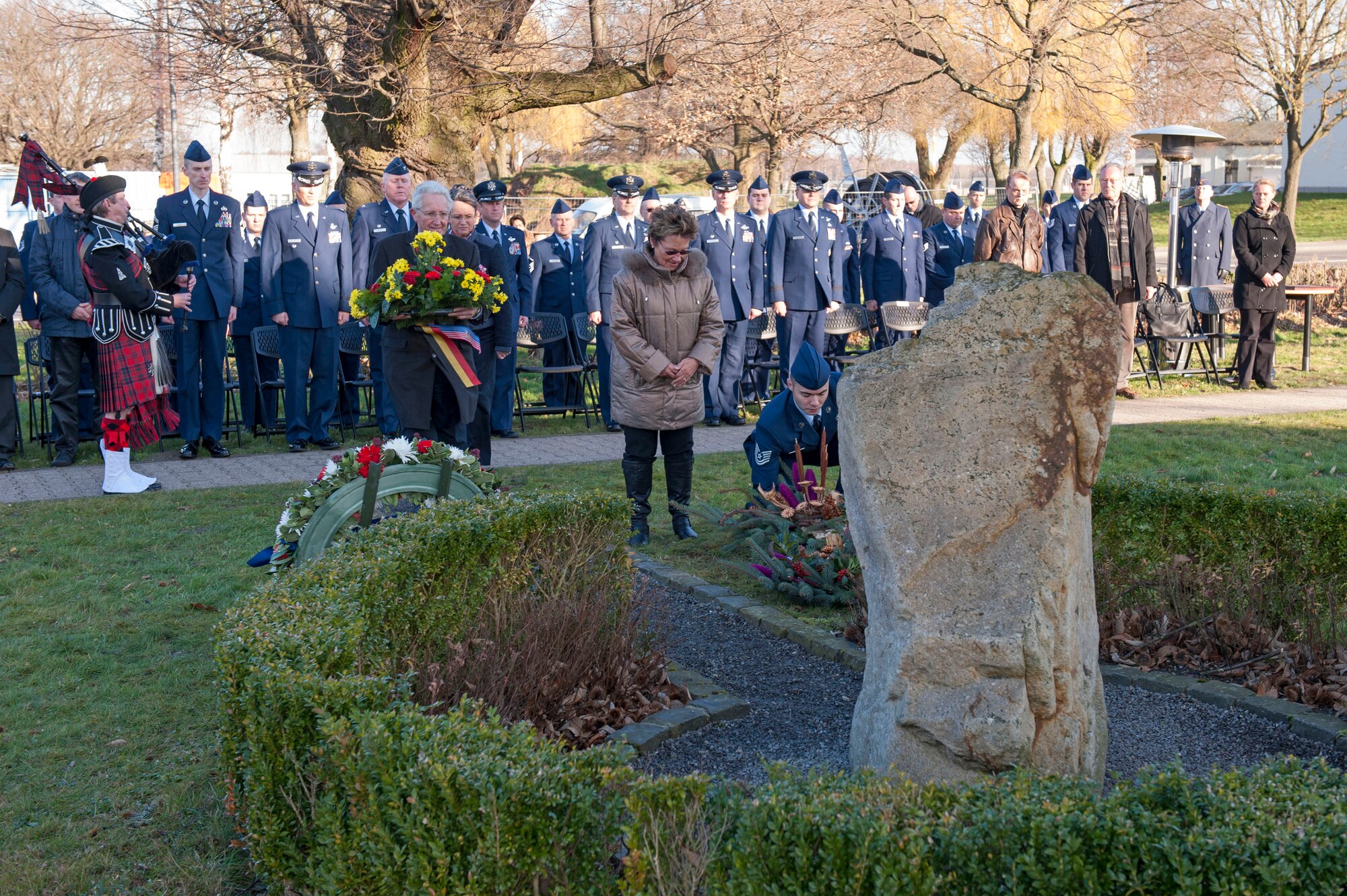Else Kriska, a German national bows her head as members place wreaths at the erected memorial for the crew of  a  KC-135 stratotanker crash in Geilenkirchen, Germany, Jan. 10, 2014. Kriska volunteered to take care of the memorial for the crew of "ESSO 77" for the last 15 years. (U.S. Air Force photo by Mr André Joosten/Released)