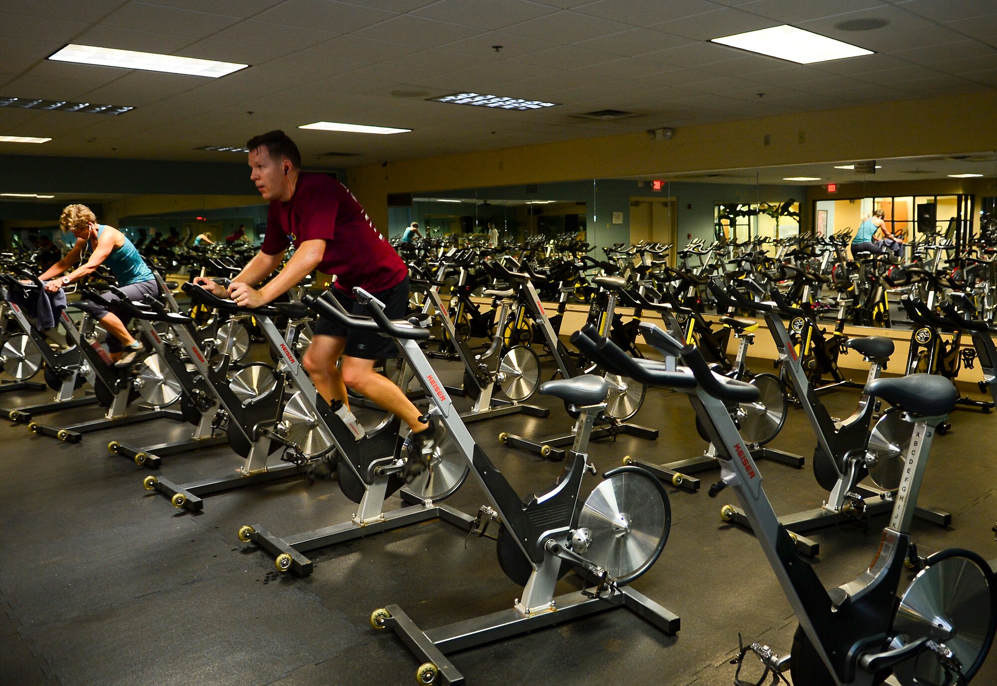 Short Fitness Center’s patrons workout in the repurposed cardio room one at MacDill Air Force Base, Fla., Jan. 31, 2014. The fitness center repurposed this room by installing spin cycles and a "Fitness on Request" kiosk, which contains pre-loaded workouts led by a virtual instructor. (U.S. Air Force photo by Senior Airman Shandresha Mitchell/ Released)