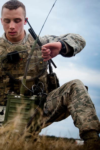 U.S. Air Force Senior Airman David Rodriguez, 822nd Base Defense Squadron radio transmitter operator readies his gear after a static-land jump during EXERCISE SAFESIDE GUARDIAN Jan. 24, 2014, at Moody Air Force Base, Ga. After conducting an operations check on his radio, Rodriguez met with other members of his unit to execute their next move. (U.S. Air Force photo by Staff Sgt. Jamal D. Sutter/Released) 
