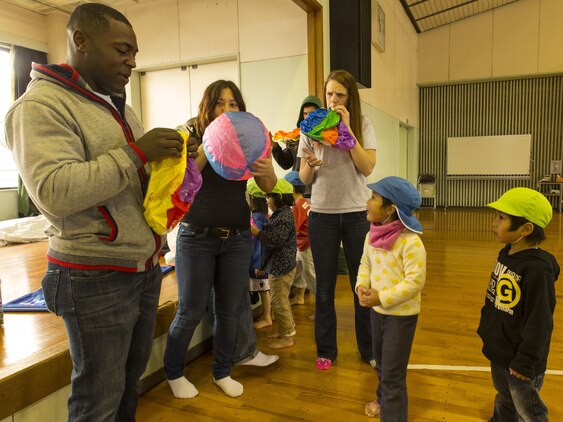 Service members aboard Marine Corps Air Station Iwakuni, Japan, inflate beach balls as they prepare to play with students from Ekimae Hoikuen Pre-School, Jan. 28, 2014, in a community relation visit hosted by Marine Memorial Chapel. Yasue Miyoshi, teacher with Ekimae Hoikuen Pre-School, said she noticed within the last few years the students open up to military members with their frequent visits to the school. The service members came to the pre-school to teach basic English skills to students and strengthen the Japanese-American relationship.