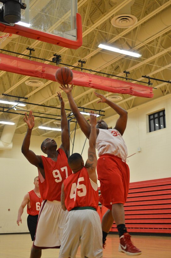 Joe Randall, player for the Marine Corps Systems Command team, takes a shot over two defenders during a Intramural American League basketball game against Manpower Management Support Branch at the Barber Physical Activity Center Feb. 3, 2014. Even though Randall shot the ball sideways, he was still able to make the basket. 