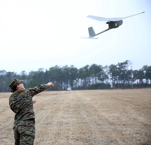 Lance Cpl. Kathryn White, a Motor Transportation Operator with Combat Logistics Battalion 6, 2nd Marine Logistics Group launches a Raven unmanned aerial vehicle aboard Camp Lejeune, N.C., Feb. 4, 2014.  The Raven is the most updated model of lightweight UAVs used for reconnaissance missions overseas.
 (U.S. Marine Corps photo by Lance Cpl. Shawn Valosin)
