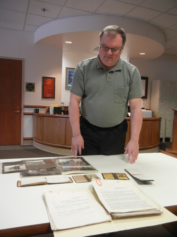Jim Ginther, archival team leader for Archives and Special Collections Branch, looks over items from the personal collection of Lt. Col. Alfred Cunningham, the Marine Corps’ first pilot, on Jan. 23, 2014, in the branch’s office in the Gray Research Center. About half of the branch’s collection consists of around 5,800 personal collections from Marines throughout history. 