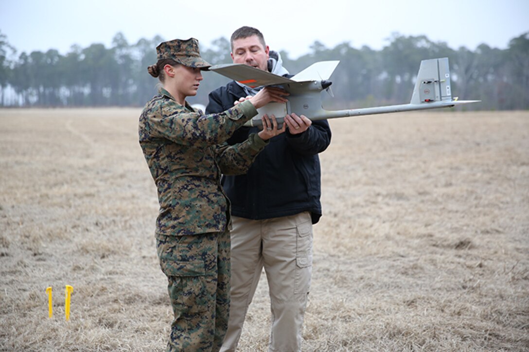 Lance Cpl. Kathryn White (left), a Motor Transportation Operator with Combat Logistics Battalion 6, 2nd Marine Logistics Group and retired Gunnery Sgt. Jim Glegola, an instructor with PMA-263 perform functions checks on a Raven unmanned aerial vehicle aboard Camp Lejeune, N.C., Feb. 4, 2014. Courses for the Raven are held every two weeks and are available to Marines from myriad military occupational specialties to train on them.  (U.S. Marine Corps photo by Lance Cpl. Shawn Valosin)