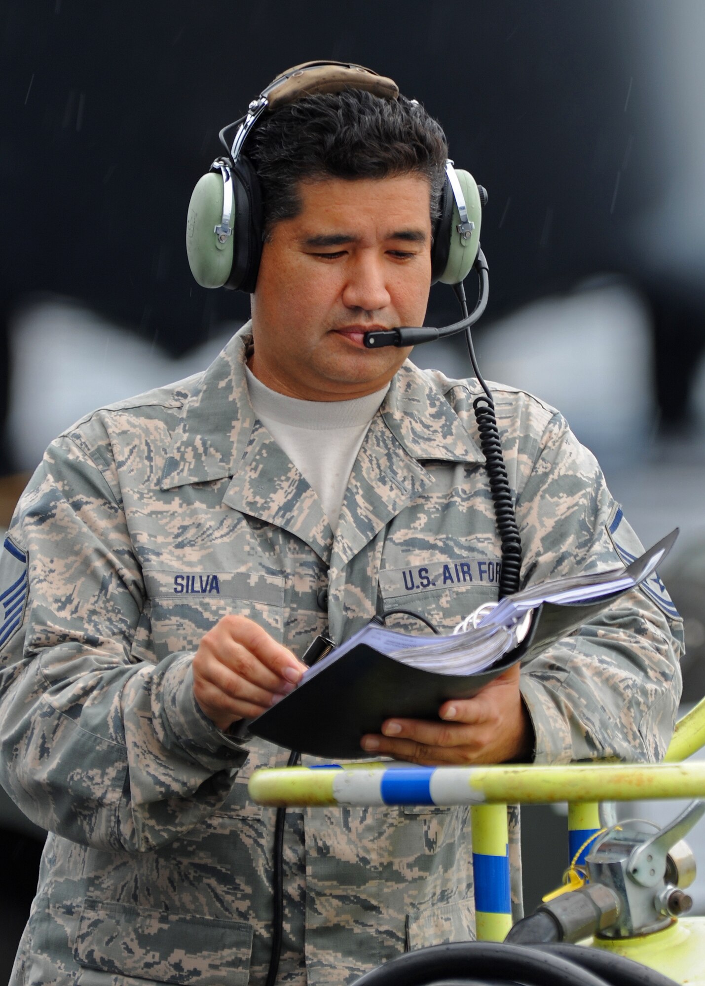 Master Sgt. Aaron Silva, 154th Aircraft Maintenance Squadron designated crew chief, reads his technical manual prior to refueling a C-17 Globemaster III on the flightline at Joint Base Pearl Harbor-Hickam, Hawaii, Feb. 4, 2014. (U.S. Air Force photo/Master Sgt. Jerome S. Tayborn)