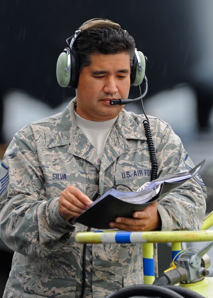 Master Sgt. Aaron Silva, 154th Aircraft Maintenance Squadron designated crew chief, reads his technical manual prior to refueling a C-17 Globemaster III on the flightline at Joint Base Pearl Harbor-Hickam, Hawaii, Feb. 4, 2014. (U.S. Air Force photo/Master Sgt. Jerome S. Tayborn)