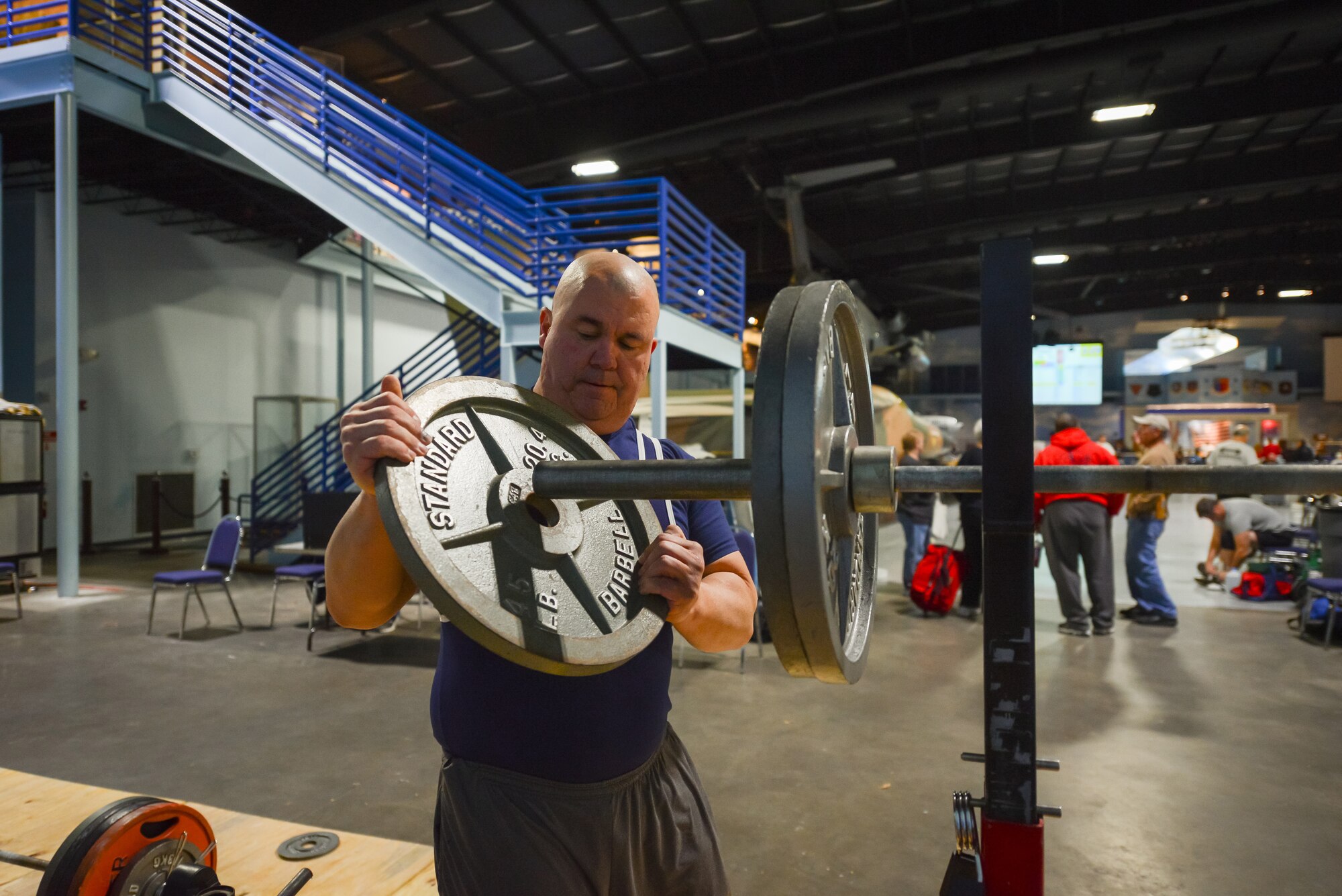 U.S. Air Force Tech. Sgt. Michael Lloyd of the 165th Airlift Wing, Georgia Air National Guard places a 45 lb. weight on a barbell, Jan. 25, 2014, at the Museum of Aviation in Warner Robins, Ga. Lloyd broke four U.S.A. Powerlifting Georgia state records at the 2014 Winter Classic and Single Ply Invitational. He set a record for squat, bench press, three event total (squat, bench press, deadlift), and bench press only for the Masters Division in his weight class at his first powerlifting competition. (U.S. Air National Guard photo by Master Sgt. Charles Delano/Released)