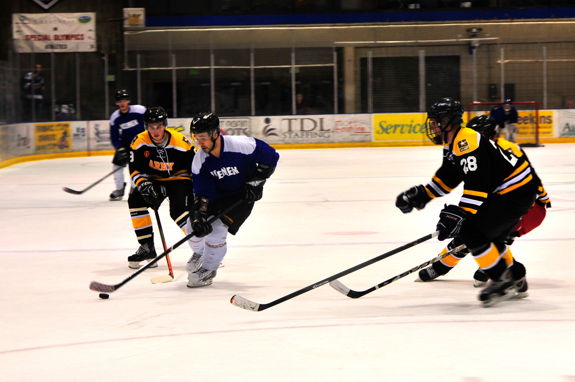 David Tidwell, Icemen center, skates the puck past three Fort Wainwright Grizzlies during an Army versus Air Force hockey exhibition game at the Big Dipper Ice Arena, Fairbanks, Alaska, Feb. 1, 2014. The game held during the Fairbanks Hockey Week Extravaganza, highlighted a friendly inter-service rivalry between Airmen from 354th Fighter Wing and Army Soldiers from the 25th Infantry Division. The Icemen swept the Grizzlies 3-0. (U.S. Air Force photo by Master Sgt. Jason Vaught/Released)  