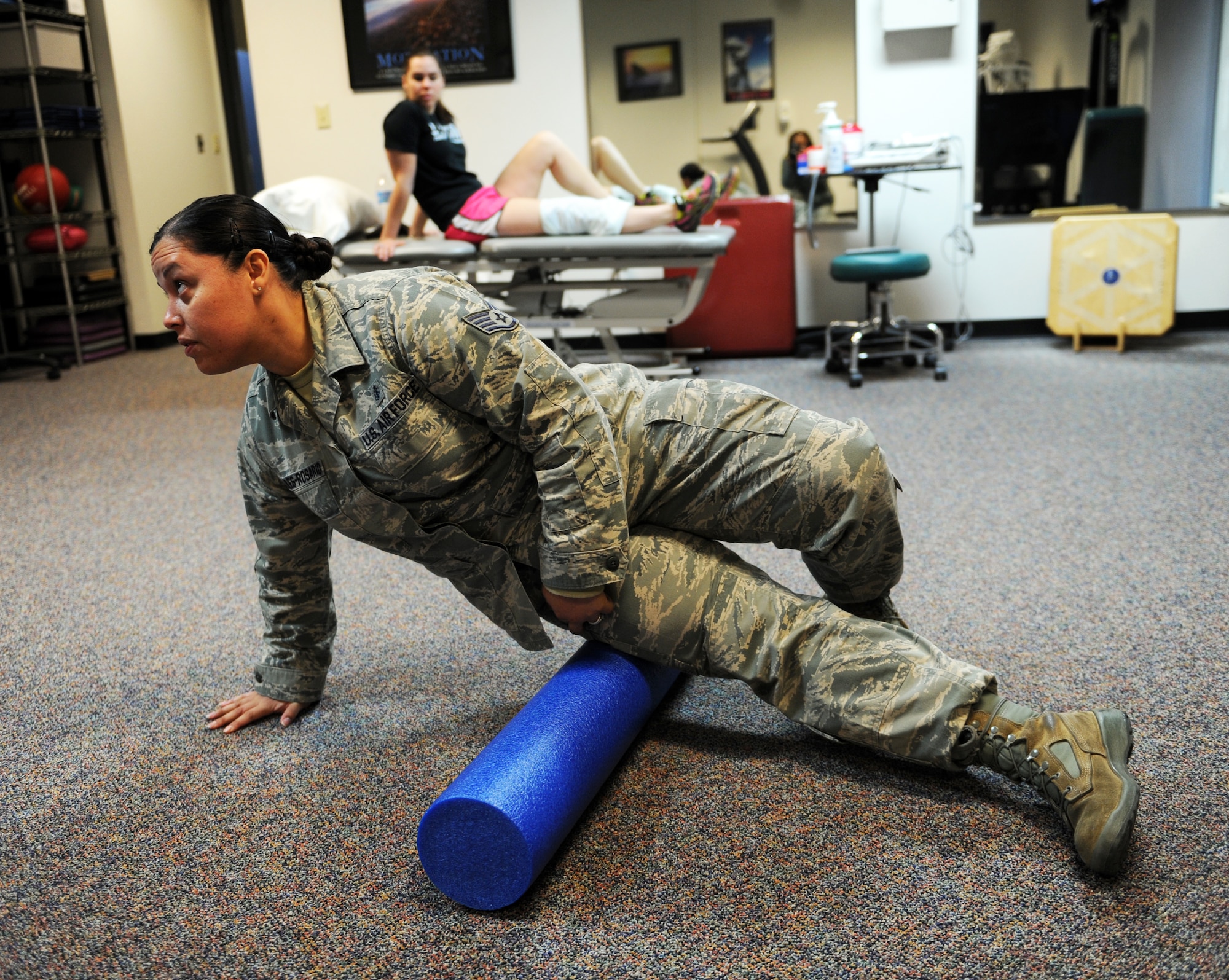 U.S. Air Force Staff Sgt. Yvonne Febles-Rosario, 7th Medical Operations Squadron, demonstrates proper foam rolling techniques Jan. 24, 2014, at Dyess Air Force Base, Texas. Active duty members who have a neuromuscular injury, disease or disorder that affects their life, job or fitness are seen by the Dyess physical therapy clinic. (U.S. Air Force photo by Airman 1st Class Kedesha Pennant/Released) 