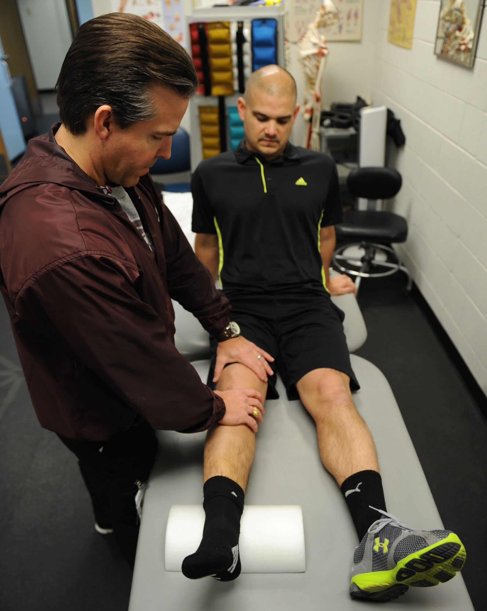 Shane Bruton, left, 7th Medical Operations Squadron physical therapist assistant, performs knee mobilizations on Tech Sgt. Darrell Leatherman, 436th Training Squadron Jan. 24, 2014,  at Dyess Air Force Base, Texas. Knee mobilizations are used to help gain full range of motion in the knee. The physical therapy clinic evaluates and examines injuries in order to return personnel to their full capability. (U.S. Air Force photo by Airman 1st Class Kedesha Pennant/Released)