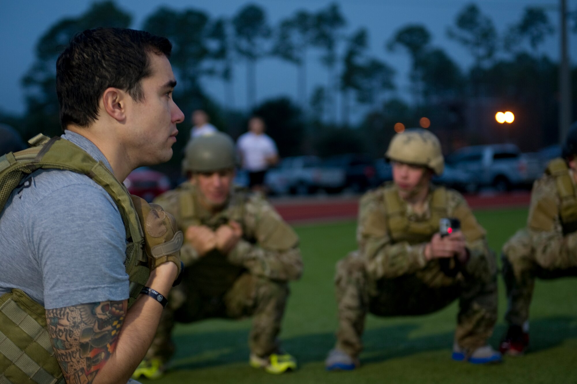 Staff Sgt. Richard Hunter, Tactical Air Control Party instructor, Detachment 3, 342nd Training Squadron, squats on the track with his flight at Hurlburt Field, Fla., Feb. 4, 2014. Hunter has been a TACP instructor for more than three years. (U.S. Air Force photo/Senior Airman Naomi Griego) 