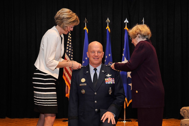VANDENBERG AIR FORCE BASE, Calif. – Lt. Gen. John W. “Jay” Raymond, Joint Functional Component Command for Space and 14th Air Force commander, kneels as his wife, Mollie (left), and his mother, Barbara Raymond, pin on his third star during his promotion ceremony Jan. 31, 2014. The ceremony was held at the Pacific Coast Club here where he was promoted from major general to lieutenant general prior to accepting command of JFCC Space and 14th AF. (U.S. Air Force photo/Michael Peterson) 