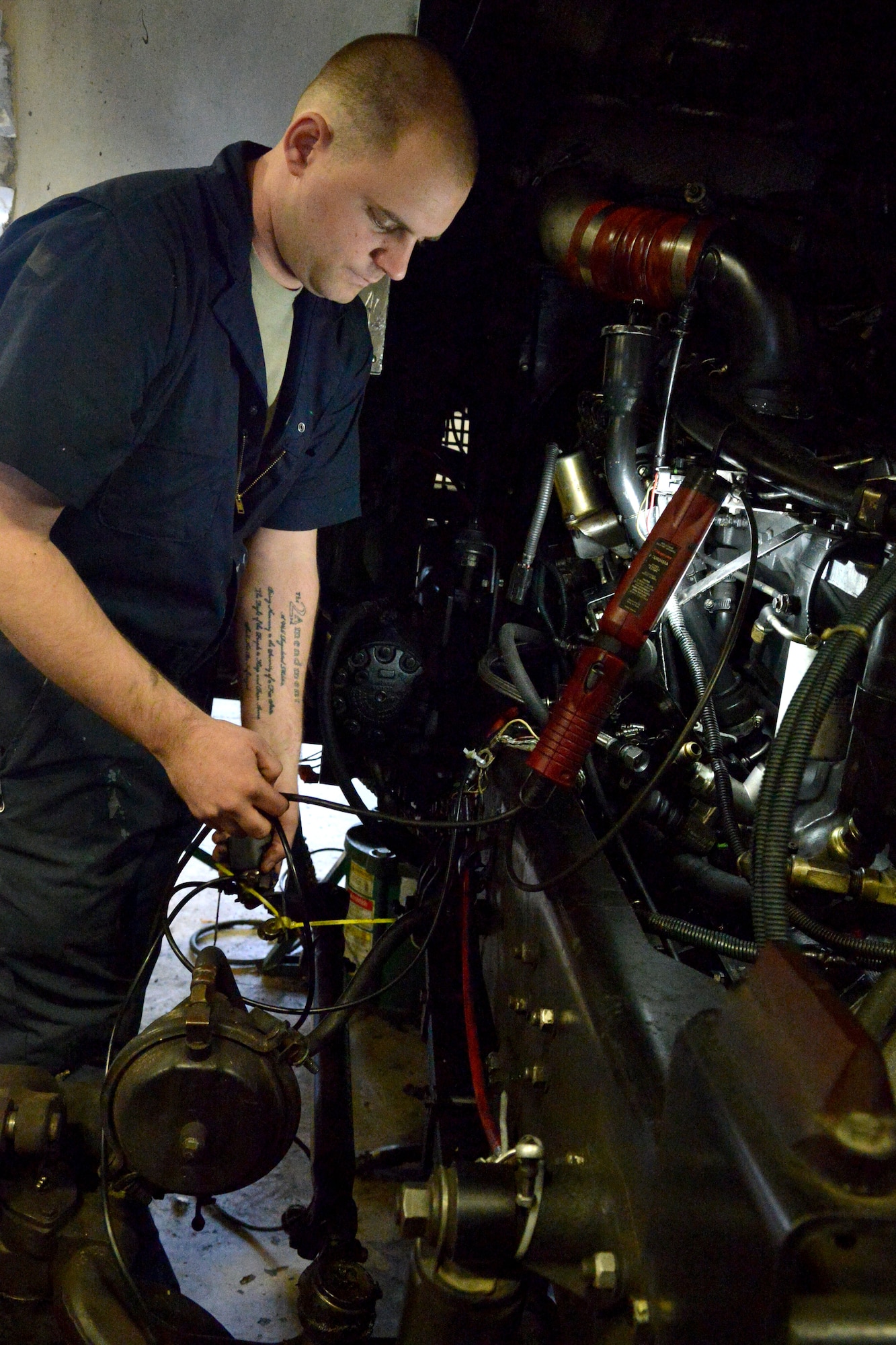 U.S. Air Force Staff Sgt. Andrew Sterrett, 20th Logistics Readiness Squadron vehicle and equipment maintainer connects several wires located inside a fire vehicle after an engine installation, Shaw Air Force Base, S.C., Feb. 4, 2014. The maintainers removed a fire truck  engine in order to replace the coolant and had to reinstall the engine back into the truck. (U.S. Air Force photo by Senior Airman Ashley L. Gardner/Released)