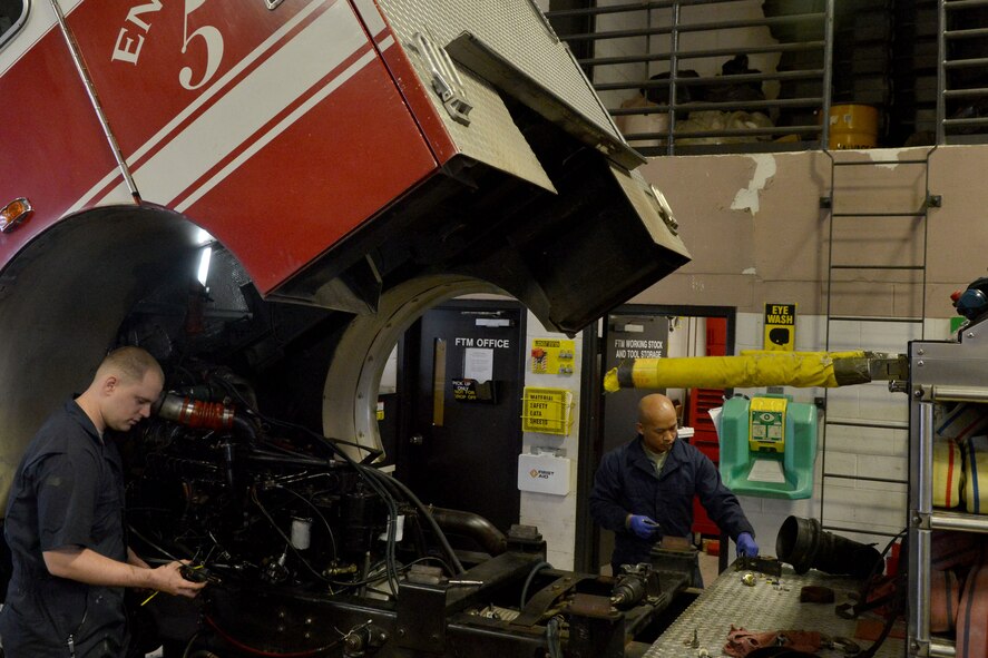 U.S. Air Force Staff Sgt. Vanny Vang and Andrew Sterrett, 20th Logistics Readiness Squadron vehicle and equipment maintainers,gather up the tools they will need to install an engine into a fire truck, Shaw Air Force Base, S.C., Feb. 4, 2014. The maintainers removed a fire truck  engine in order to replace the coolant and had to reinstall the engine into the truck.( U.S. Air Force photo by Senior Airman Ashley L. Gardner/Released)