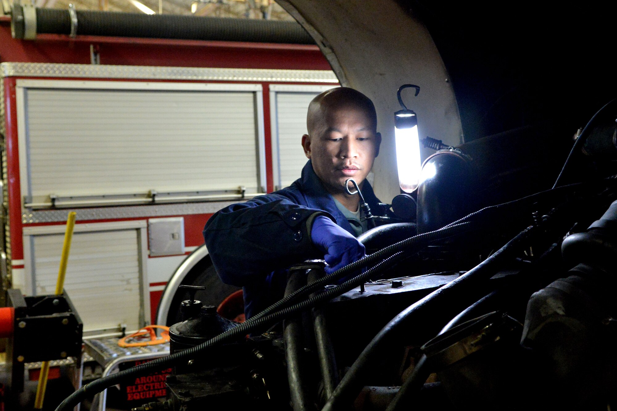 U.S. Air Force Staff Sgt. Vanny Vang, 20th Logistics Readiness Squadron vehicle and equipment maintainer, inspects fire truck engine parts during an installation,Shaw Air Force Base, S.C., Feb. 4, 2014. The maintainers removed a fire truck  engine in order to replace the coolant and had to reinstall the engine into the truck.( U.S. Air Force photo by Senior Airman Ashley L. Gardner/Released)