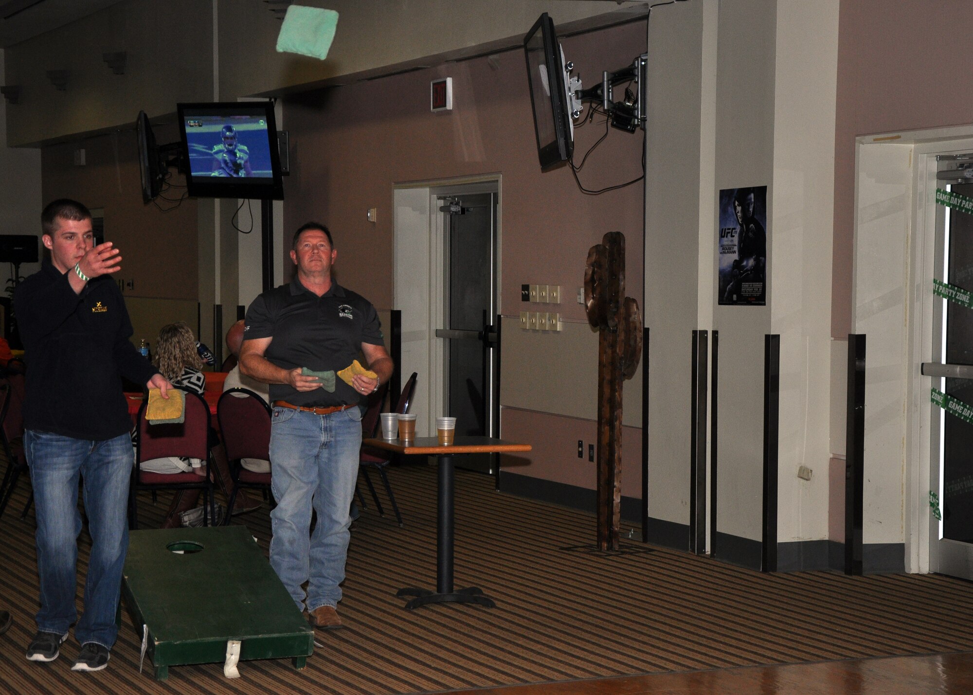 GOODFELLOW AIR FORCE BASE, Texas – Airman 1st Class Marcus Andersen, 316th Training Squadron student, throws a bean bag in a game against Tim White, San Angelo Bandits president, during the Super Bowl XLVIII party at the Event Center Feb. 2. Bandit team members came to support the event and gave away Bandit related items to service members. (U.S. Air Force photo/ Senior Airman Joshua Edwards)