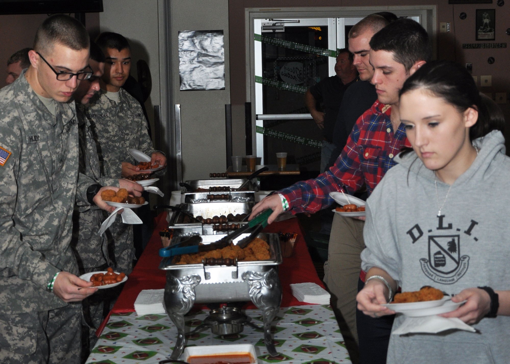GOODFELLOW AIR FORCE BASE, Texas – Service members pick food from a buffet line during the Super Bowl XLVIII party at the Event Center Feb. 2. The 17th Force Support Squadron hosts the annual party which offers Goodfellow members a place to watch the Super Bowl, play games and win raffle prizes. (U.S. Air Force photo/ Senior Airman Joshua Edwards)