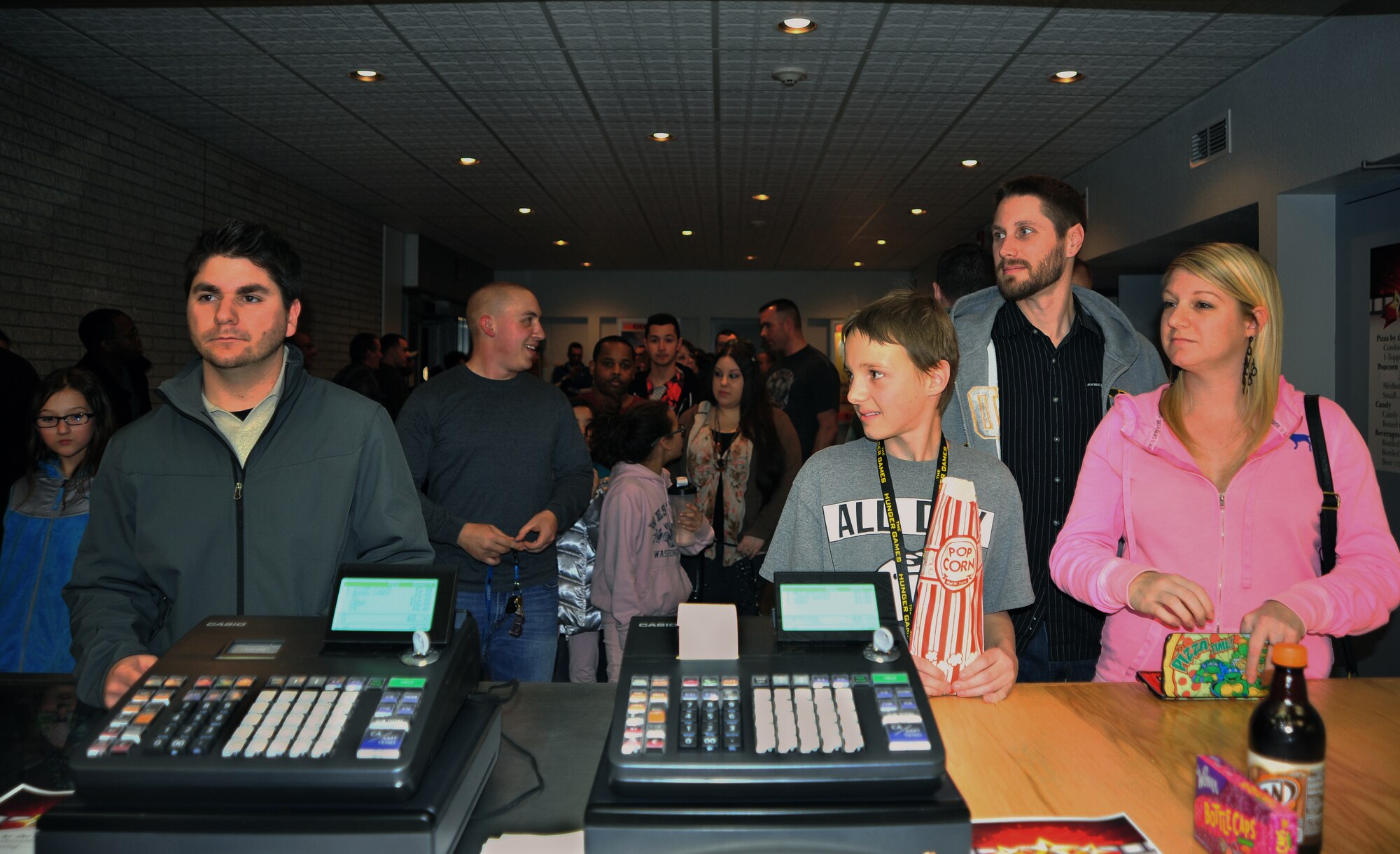 Members of the 27th Special Operations Wing wait in line at the concession stand prior to heading into the auditorium at the grand reopening of the Cannon Theater Jan. 31, 2014 at Cannon Air Force Base, N.M. The theater, which closed in early 2013 due to funding issues, was able to reopen as a result of the Navy DVD Program. (U.S. Air Force photo/Senior Airman Whitney Tucker)
