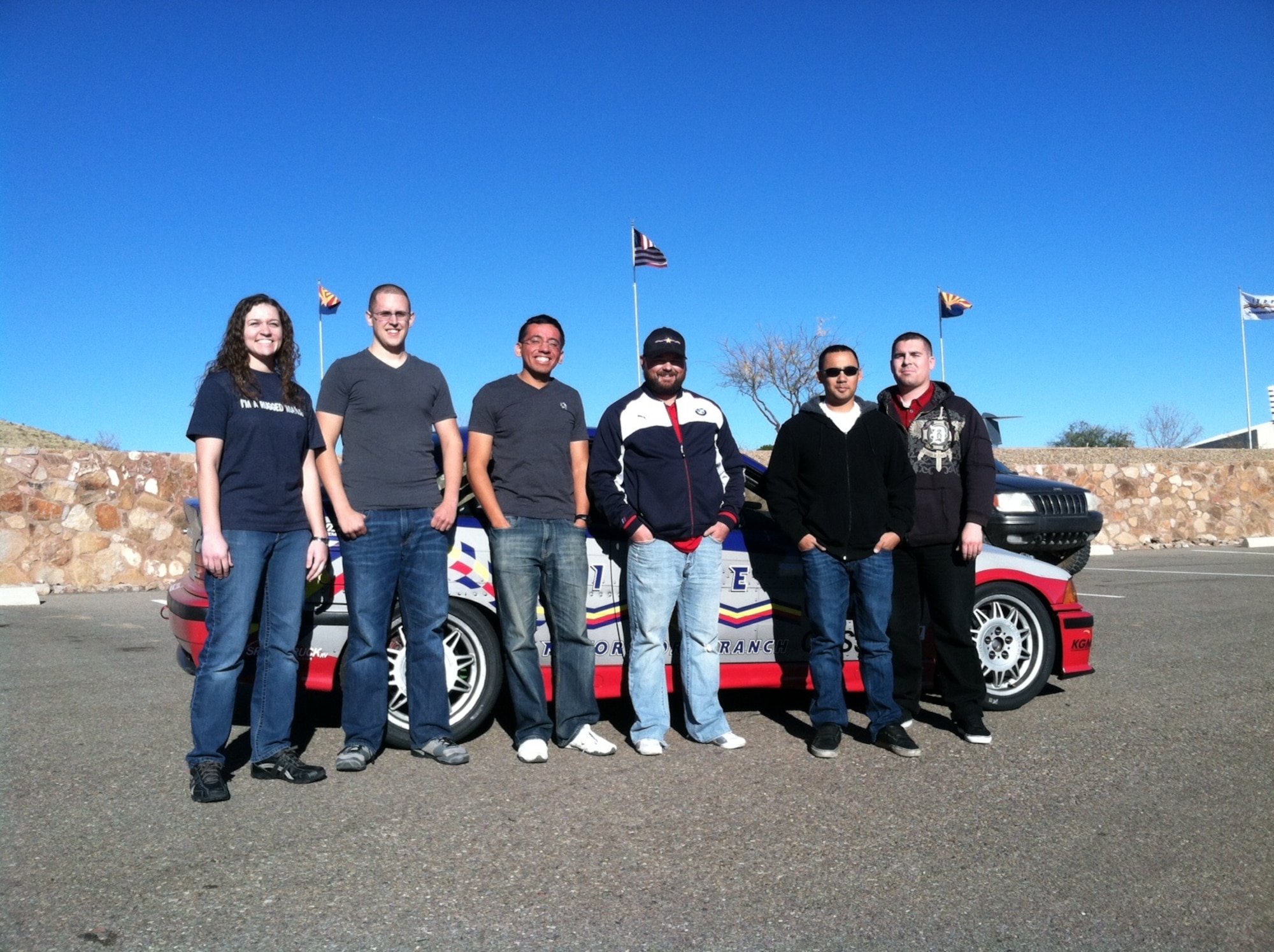 U.S. Air Force Airmen stand with a racecar driver at Inde Motorsports Ranch in Willcox, Ariz., Jan. 17, 2014. Five Davis-Monthan Air Force Base, Ariz., Airmen received the opportunity to race cars at the private club, after Graham Dorland, owner of IMR, met Chief Master Sgt. Dawna Cnota, 355th Fighter Wing command chief, and wanted to express gratitude to base personnel. (Courtesy photo)